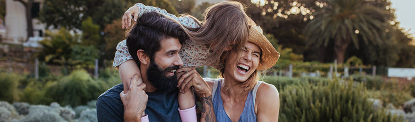 Southern Cross Health Insurance plans banner A young couple together with their daughter who is sat on her dad's shoulders