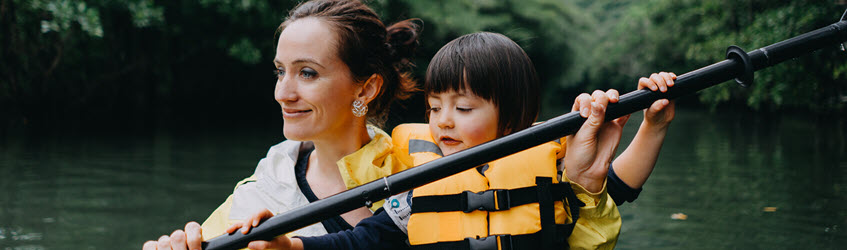 A mother and daughter rowing in a canoe