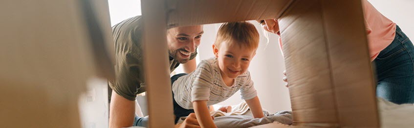 Southern Cross Life Insurance - member offer A mother and father and their child playing pretend with a cardboard box